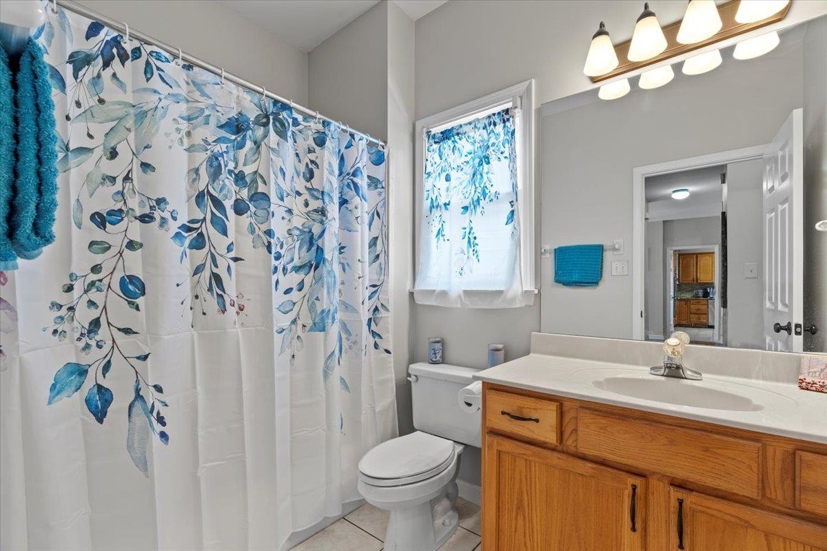 1675 John Ridge Drive Collierville, TN 38017 - Photo 12 of 39 Bathroom featuring toilet, tile patterned flooring, vanity, and a shower with shower curtain