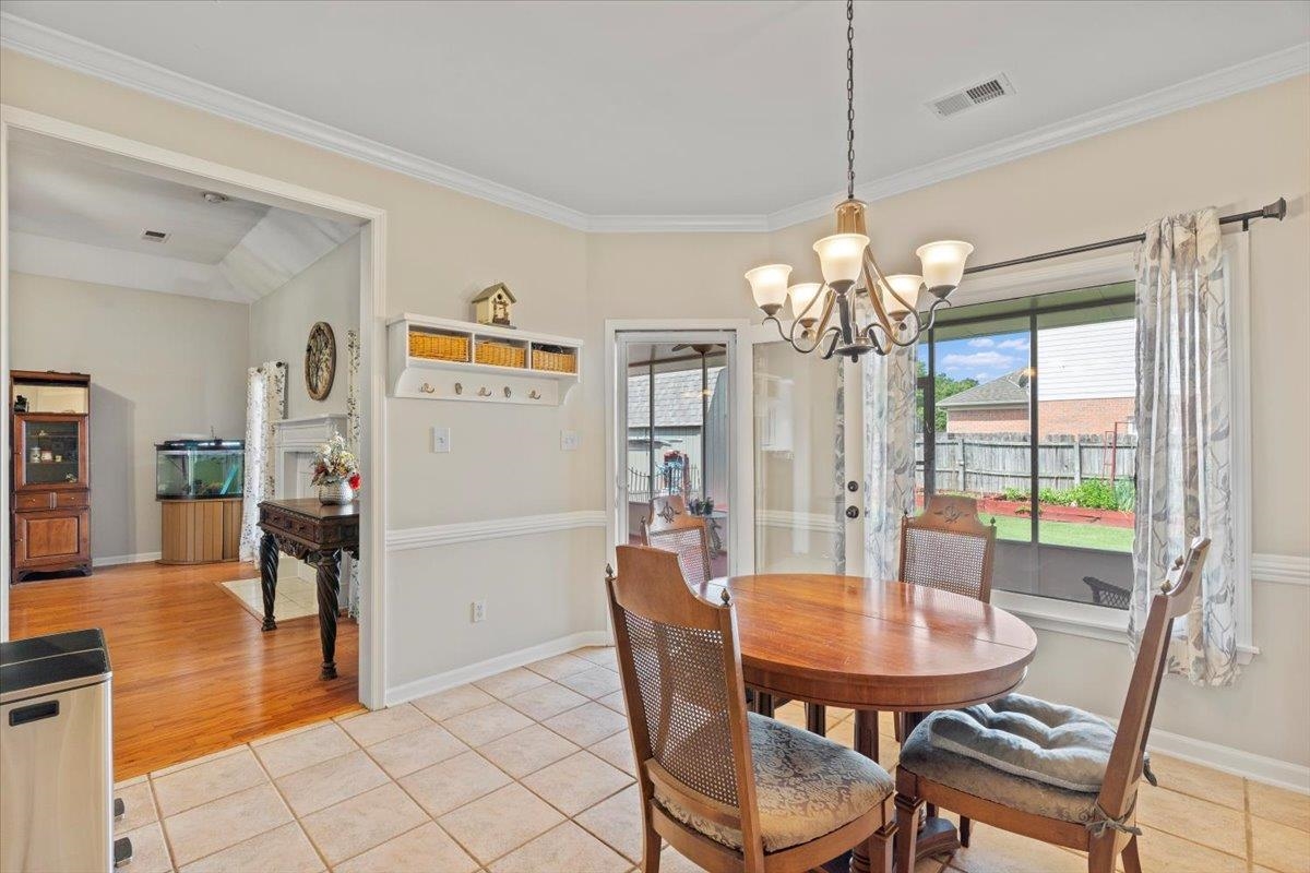1675 John Ridge Drive Collierville, TN 38017 - Photo 17 of 39 Dining room featuring a chandelier, crown molding, baseboards, and light tile patterned floors