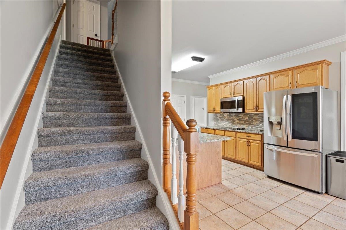 1675 John Ridge Drive Collierville, TN 38017 - Photo 18 of 39 Stairs featuring ornamental molding, tile patterned floors, and baseboards