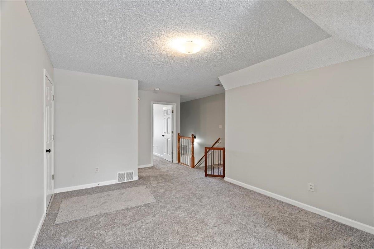 1675 John Ridge Drive Collierville, TN 38017 - Photo 26 of 39 Carpeted spare room with a textured ceiling and baseboards