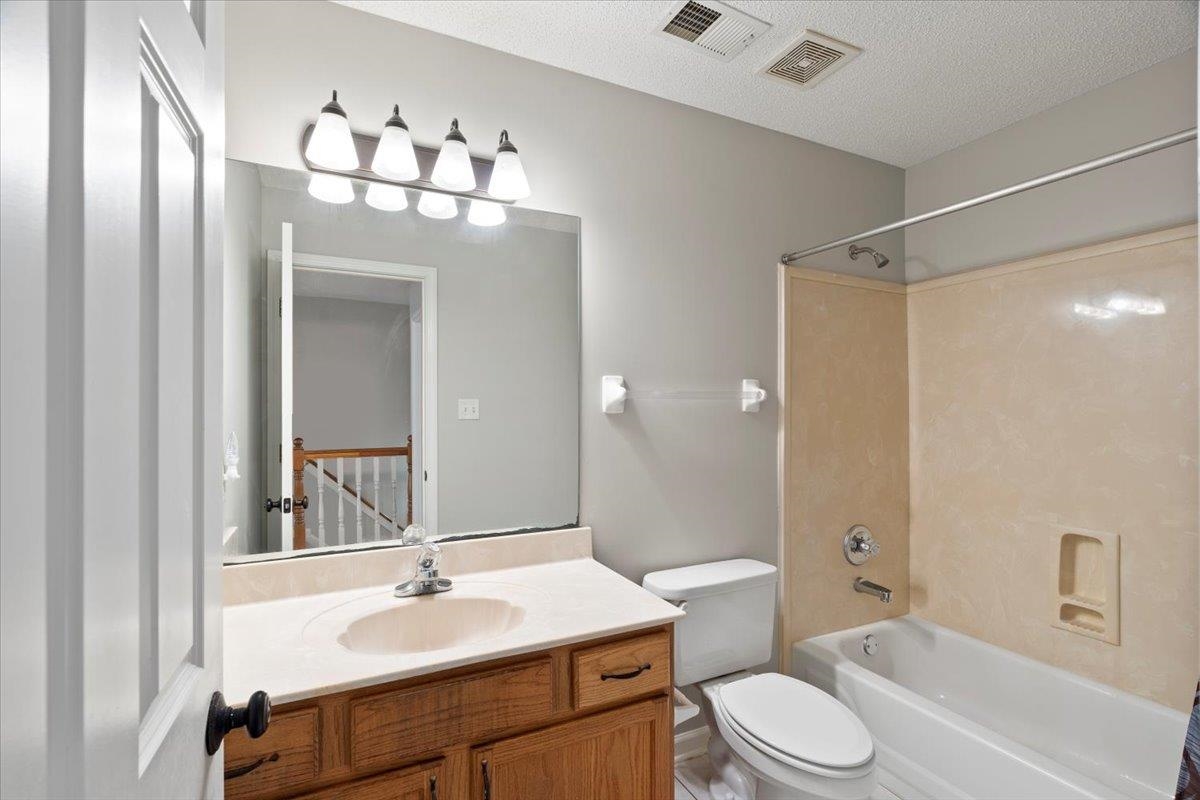 1675 John Ridge Drive Collierville, TN 38017 - Photo 27 of 39 Full bathroom featuring shower combination, vanity, toilet, and a textured ceiling
