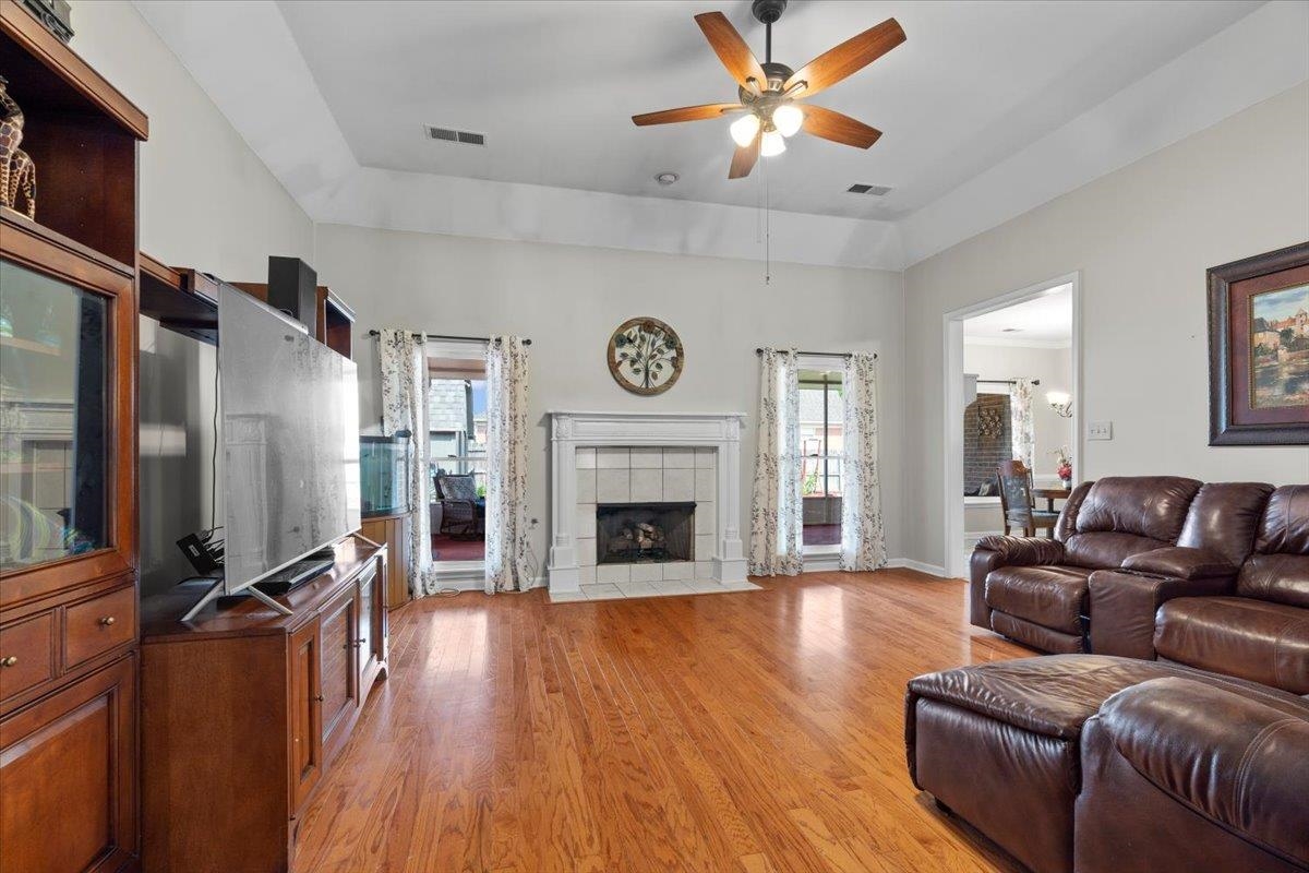1675 John Ridge Drive Collierville, TN 38017 - Photo 7 of 39 Living area with ceiling fan, light wood-type flooring, and a tile fireplace