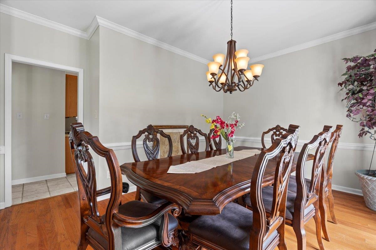 1675 John Ridge Drive Collierville, TN 38017 - Photo 9 of 39 Dining space featuring a chandelier, light wood-style flooring, ornamental molding, and baseboards