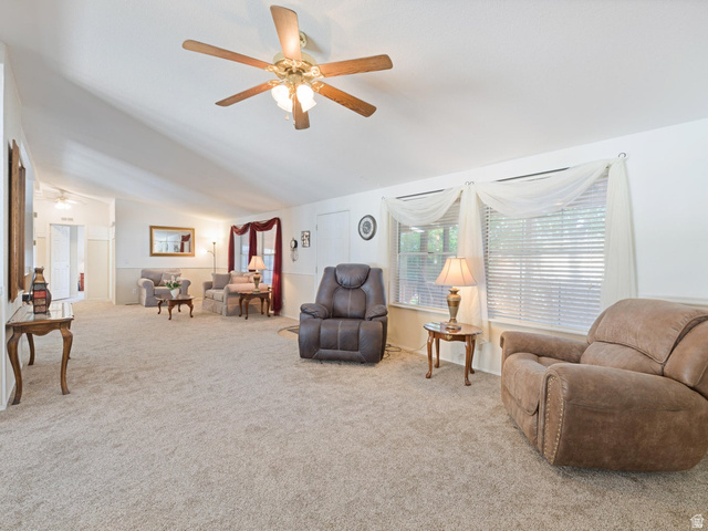 3941 West 40 North Hurricane, UT 84737 - Photo 12 of 55 Spacious living area featuring vaulted ceilings, a ceiling fan with integrated lighting, and neutral carpet flooring
