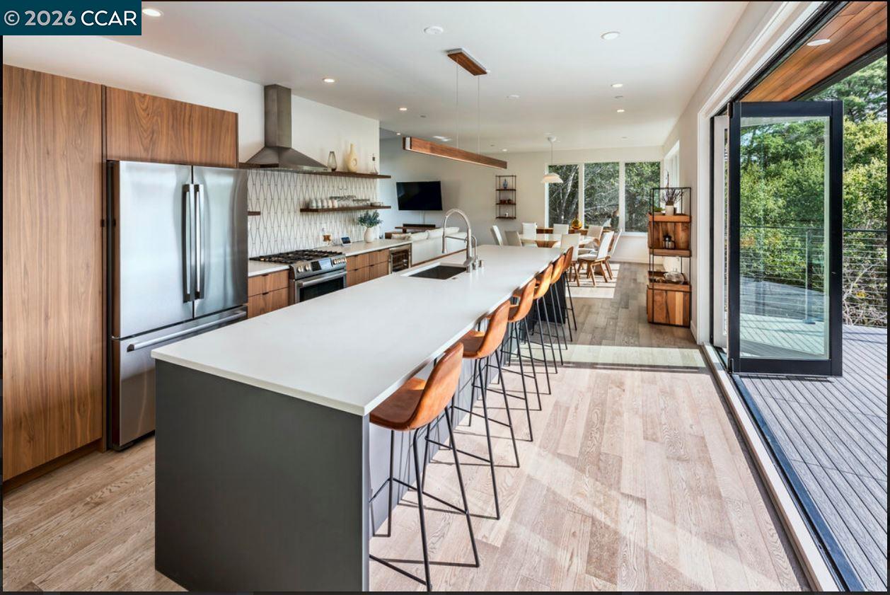 1110 Sterling Avenue Berkeley, CA 94708 - Photo 11 of 25 a kitchen with stainless steel appliances kitchen island granite countertop a refrigerator a stove top oven and a sink with wooden floor
