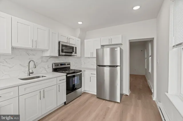 a kitchen with a refrigerator stove top oven and sink