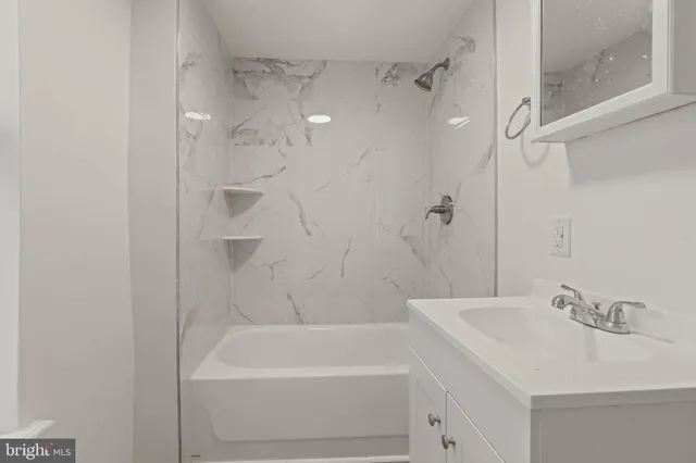 a bathroom with a tub sink vanity and a mirror