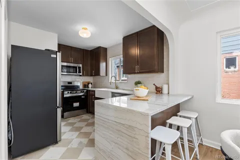 a kitchen with a refrigerator stove top oven and sink