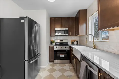 a kitchen with stainless steel appliances granite countertop a refrigerator stove and sink