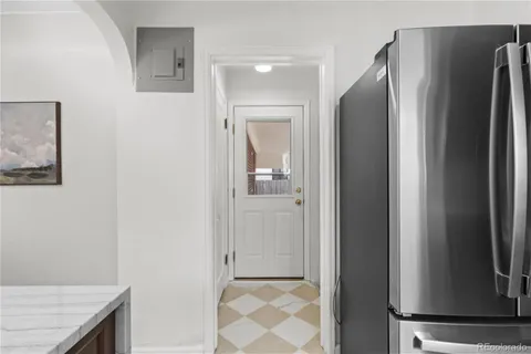 a view of a kitchen with a refrigerator and mirror