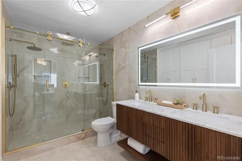 a bathroom with a double vanity sink toilet and shower