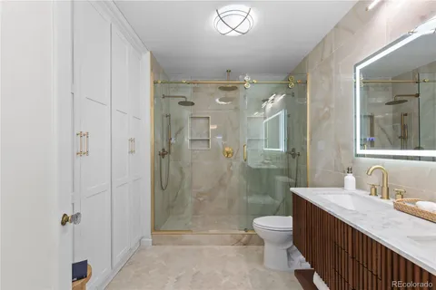 a bathroom with a double vanity sink toilet and shower