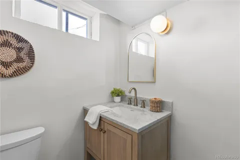 a bathroom with a sink a toilet and a mirror