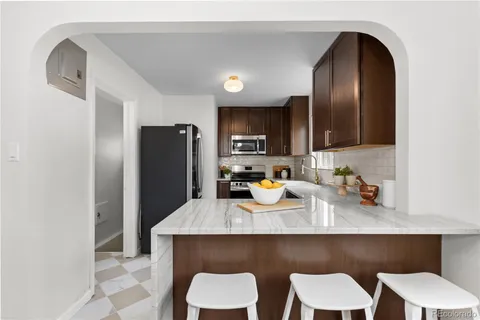 a kitchen with a table chairs refrigerator and microwave