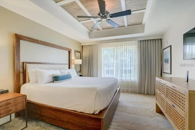 a bedroom with a bed a window and a chandelier