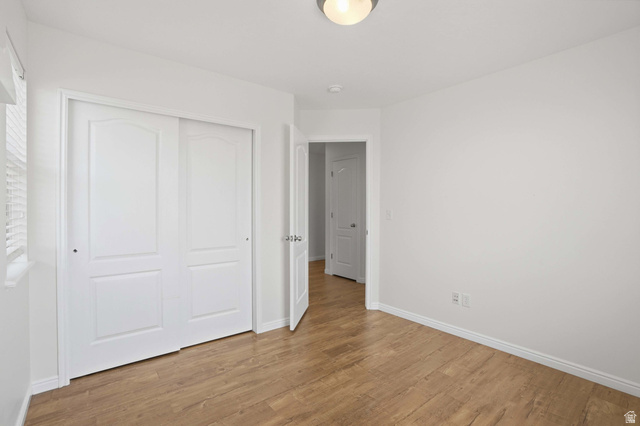 2007 Fielding Hill Lane Draper, UT 84020 - Photo 28 of 83 White interior room featuring wood-finish flooring, white baseboards, and a semi-flush mount ceiling light fixture