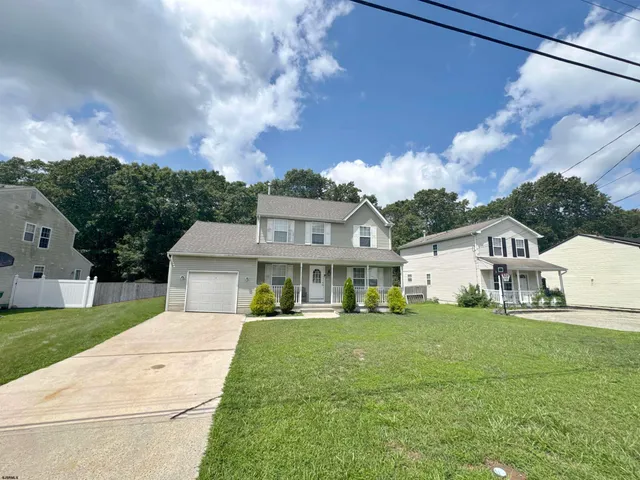a front view of a house with a garden and trees