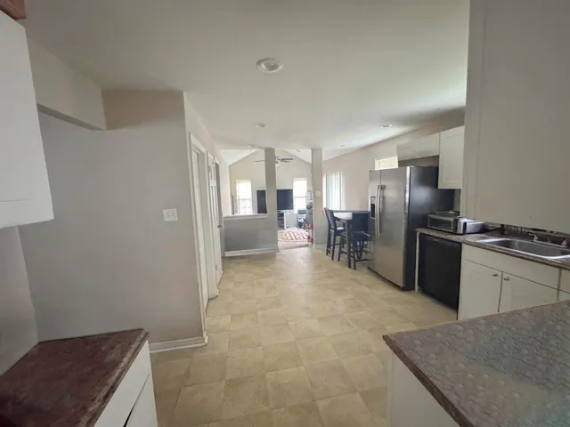 a large kitchen with a refrigerator and a sink