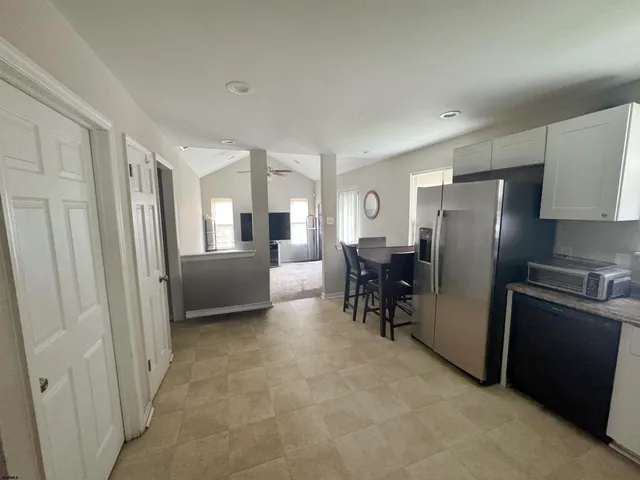 a view of a kitchen with furniture refrigerator and windows