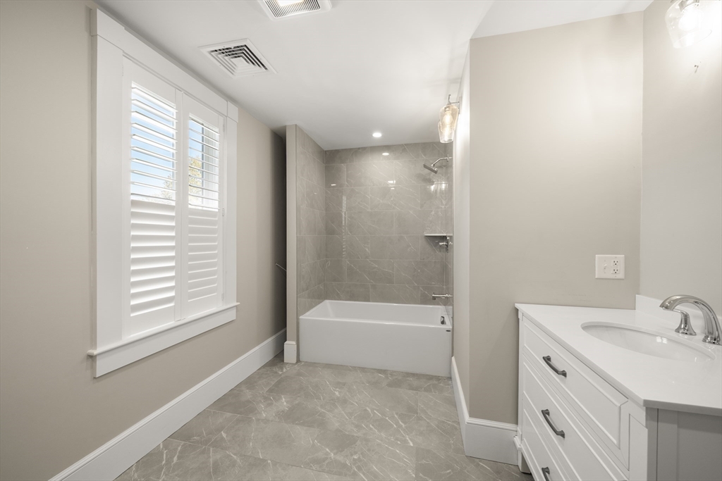 74-76 Butler Road Quincy, MA 02169 - Photo 31 of 41 a bathroom with a tub sink and a mirror