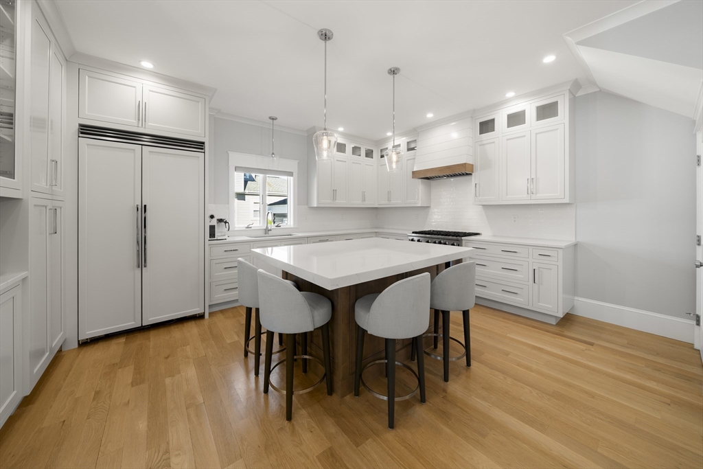 74-76 Butler Road Quincy, MA 02169 - Photo 6 of 41 a kitchen with kitchen island a dining table chairs sink and stove