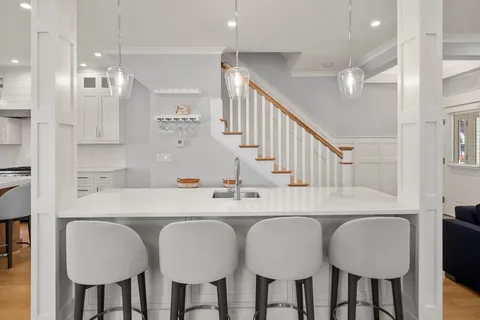 a kitchen with cabinets a sink dining table and chairs