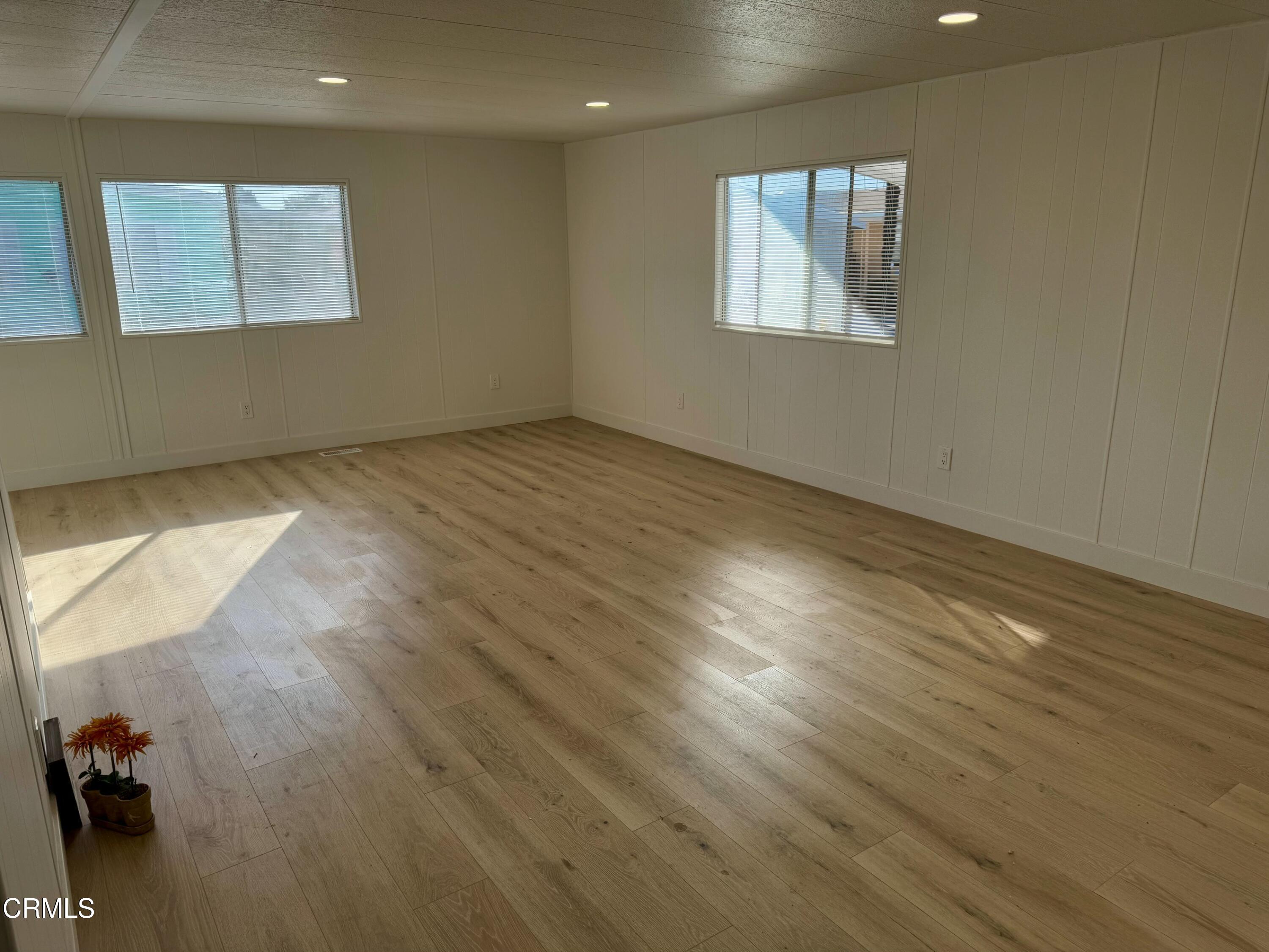 285 Ibsen Place, Unit 10 Oxnard, CA 93033 - Photo 13 of 32 an empty room with wooden floor and windows