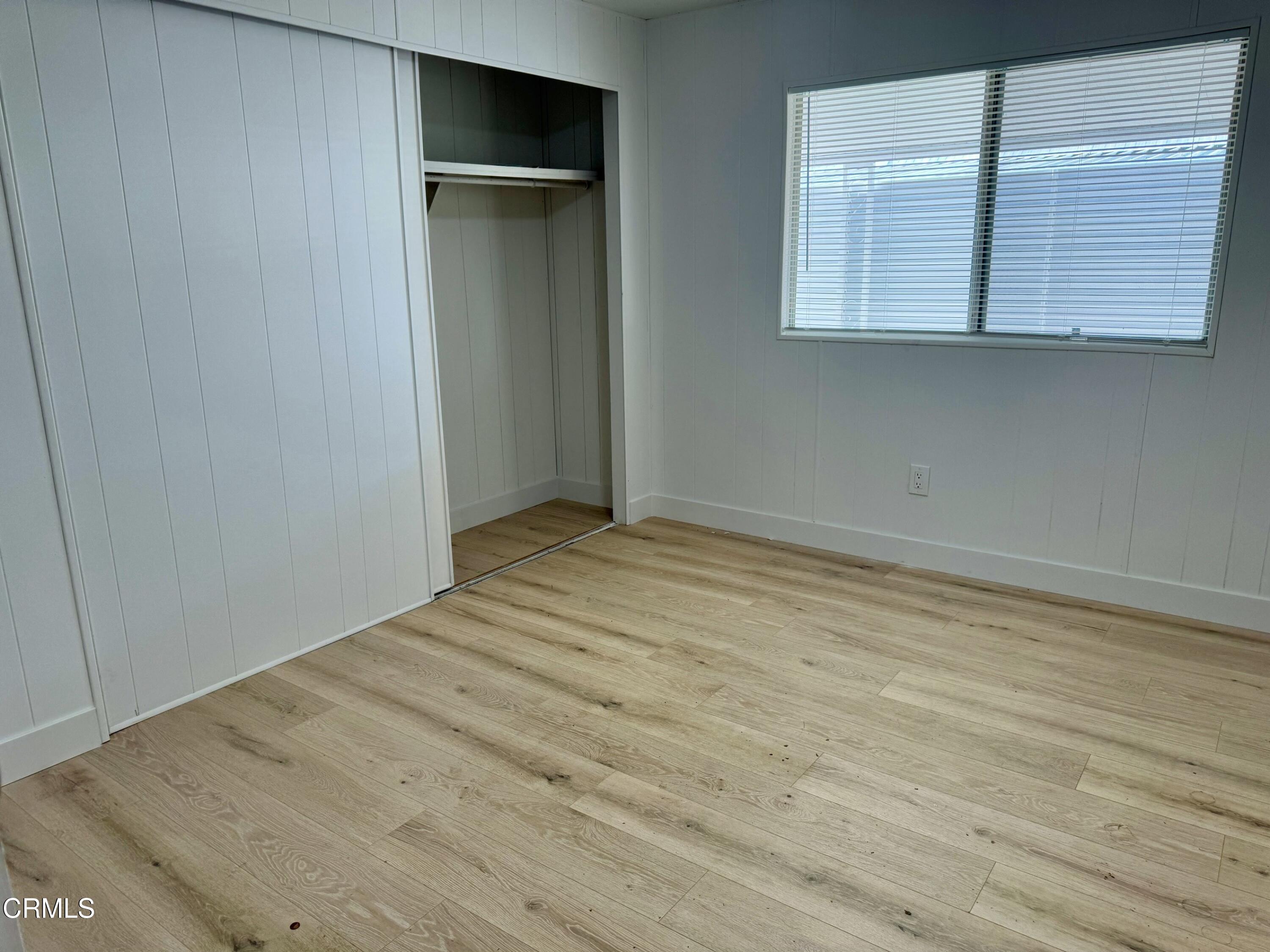 285 Ibsen Place, Unit 10 Oxnard, CA 93033 - Photo 18 of 32 an empty room with wooden floor and windows