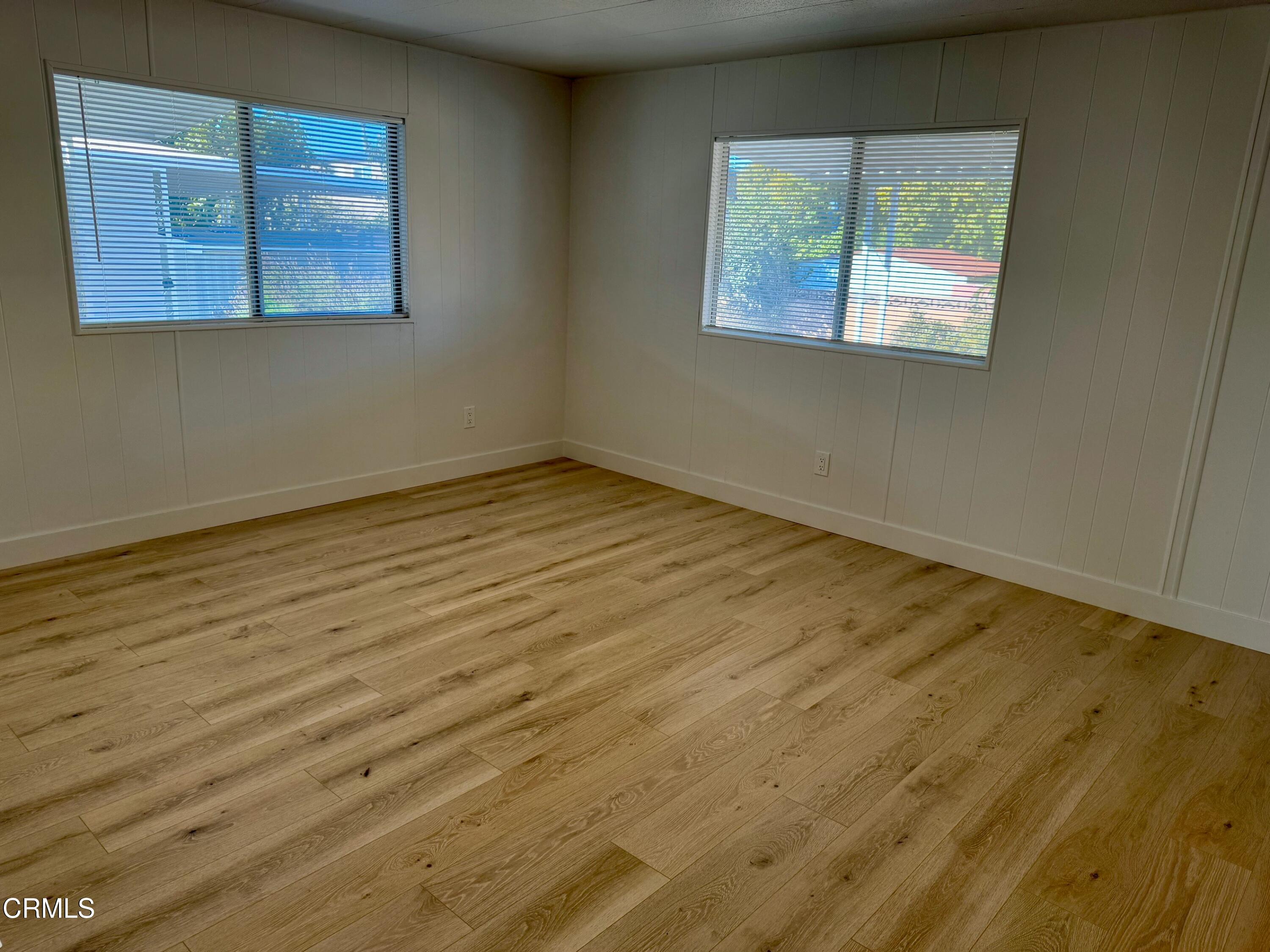 285 Ibsen Place, Unit 10 Oxnard, CA 93033 - Photo 19 of 32 a view of an empty room with wooden floor and a window