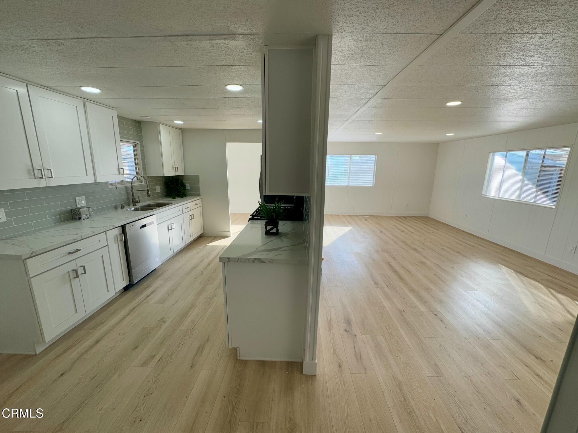 285 Ibsen Place, Unit 10 Oxnard, CA 93033 - Photo 25 of 32 a large kitchen with cabinets wooden floor and stainless steel appliances