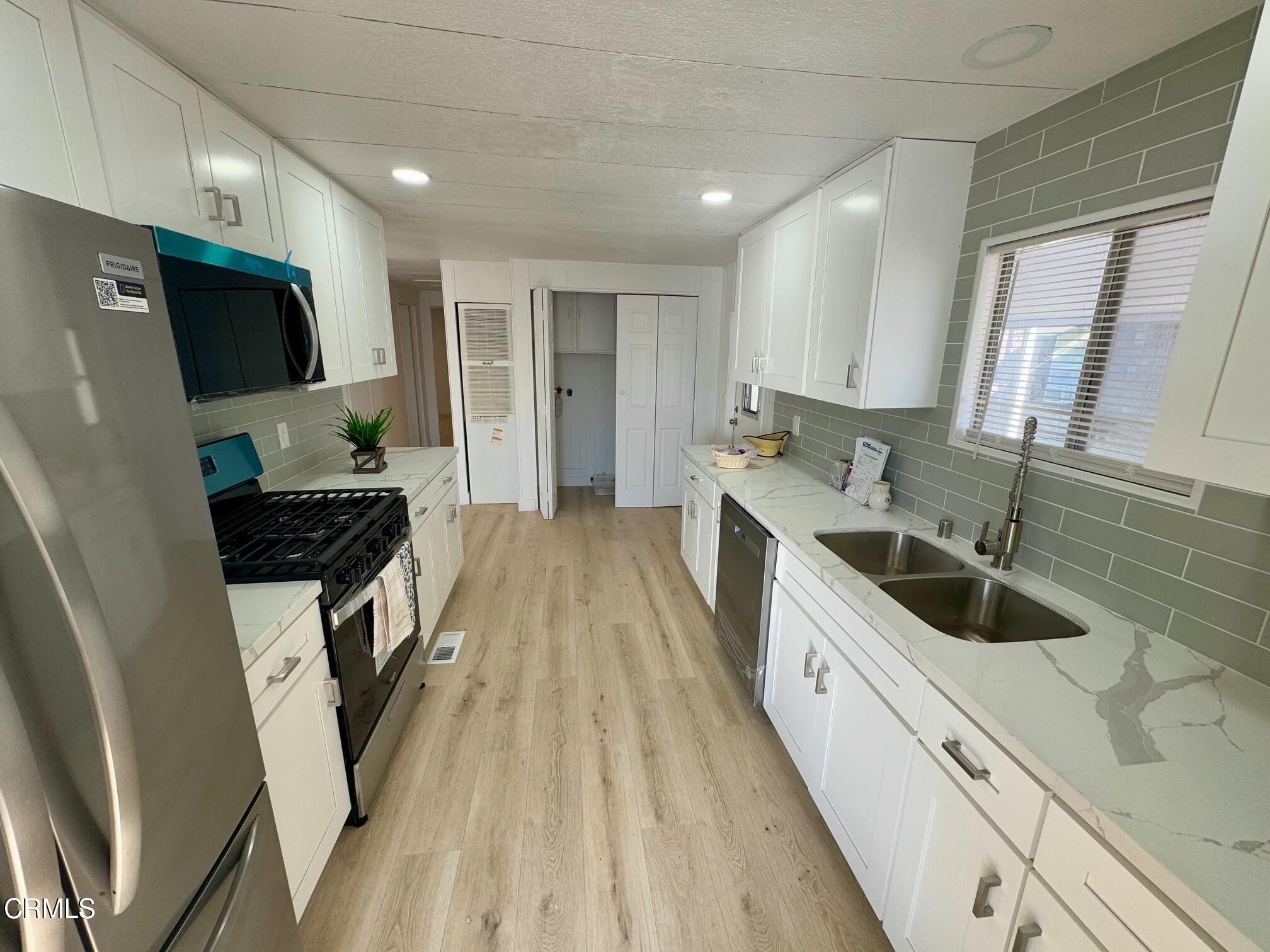 285 Ibsen Place, Unit 10 Oxnard, CA 93033 - Photo 10 of 32 a kitchen with a sink stove top oven and refrigerator
