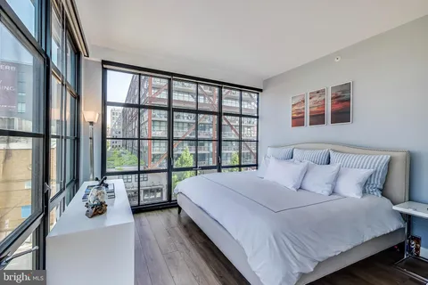 a bedroom with a bed and a large window