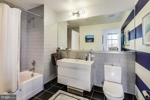 a bathroom with a sink toilet a mirror and bathtub