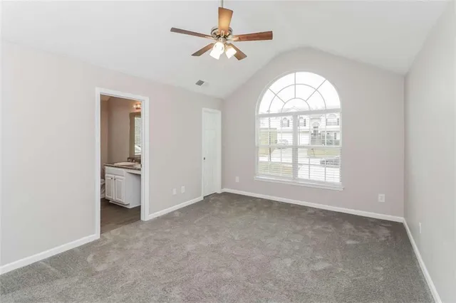 an empty room with fan and windows