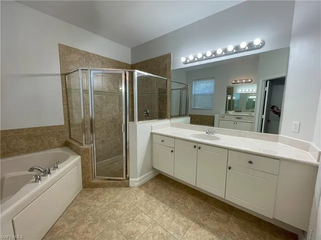 a spacious bathroom with a tub sink shower and mirror