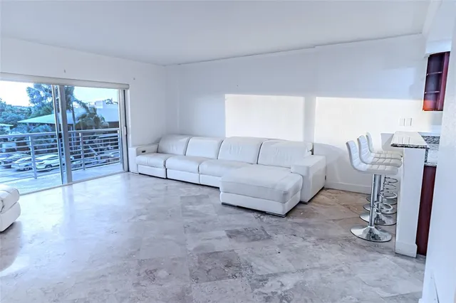 a living room with furniture a rug and white walls