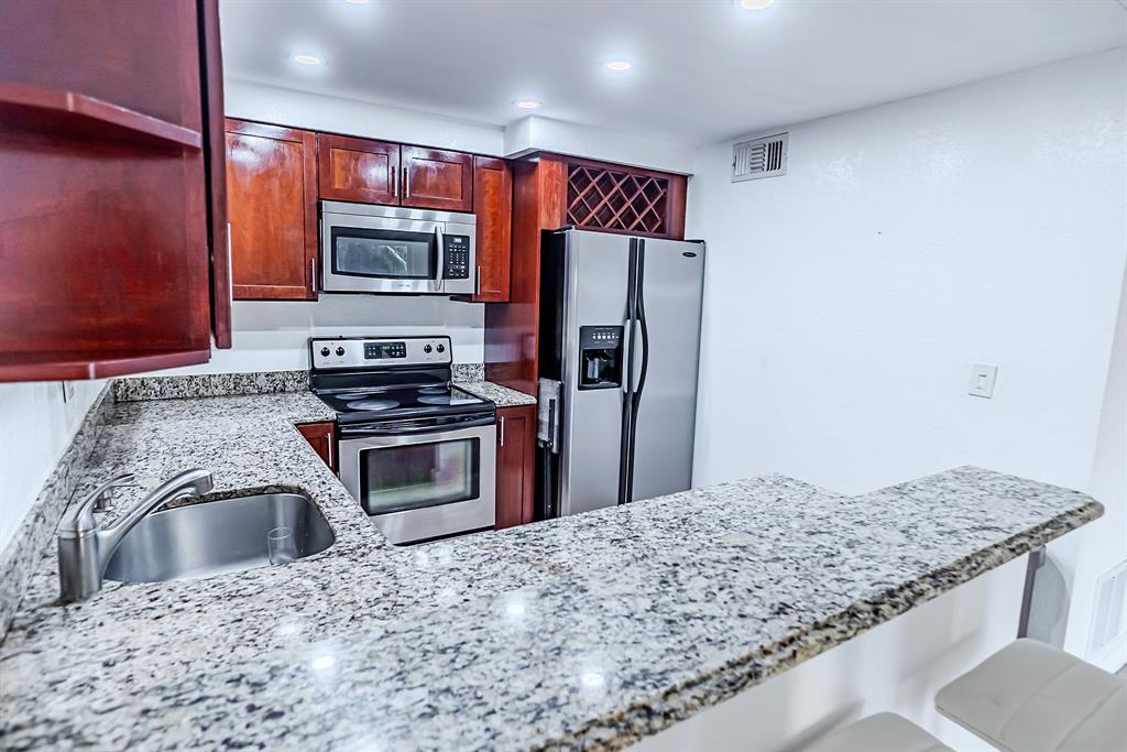 2900 Northeast 30th Street, Unit 3F Fort Lauderdale, FL 33306 - Photo 4 of 30 a kitchen with stainless steel appliances kitchen island granite countertop a refrigerator stove and oven