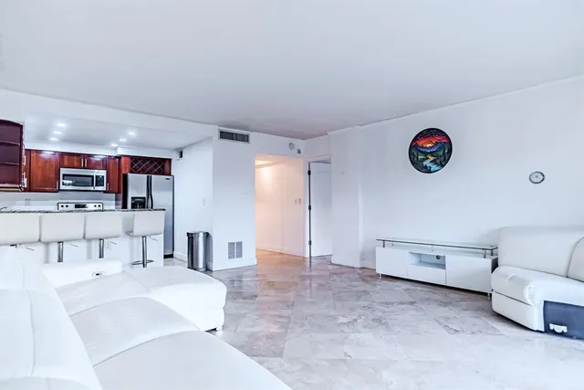 a living room with furniture and a kitchen view