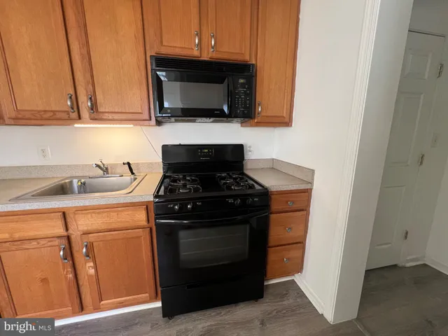 a kitchen with stainless steel appliances granite countertop white cabinets and a stove top oven