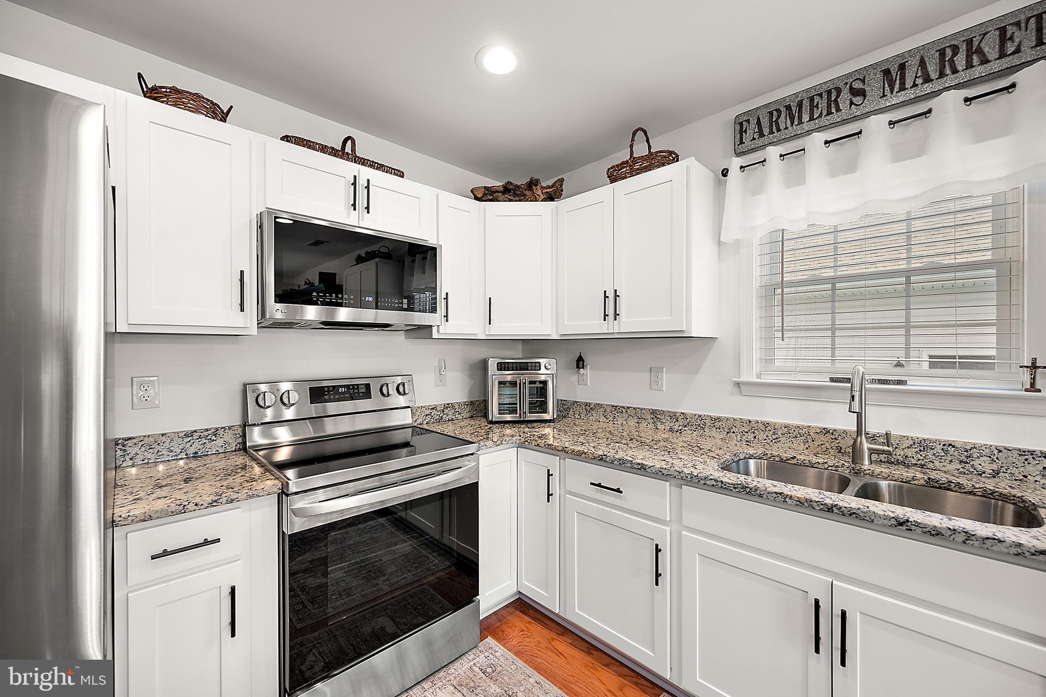 6098 Tarry Town Road Salisbury, MD 21801 - Photo 22 of 60 a kitchen with granite countertop a sink stainless steel appliances and white cabinets