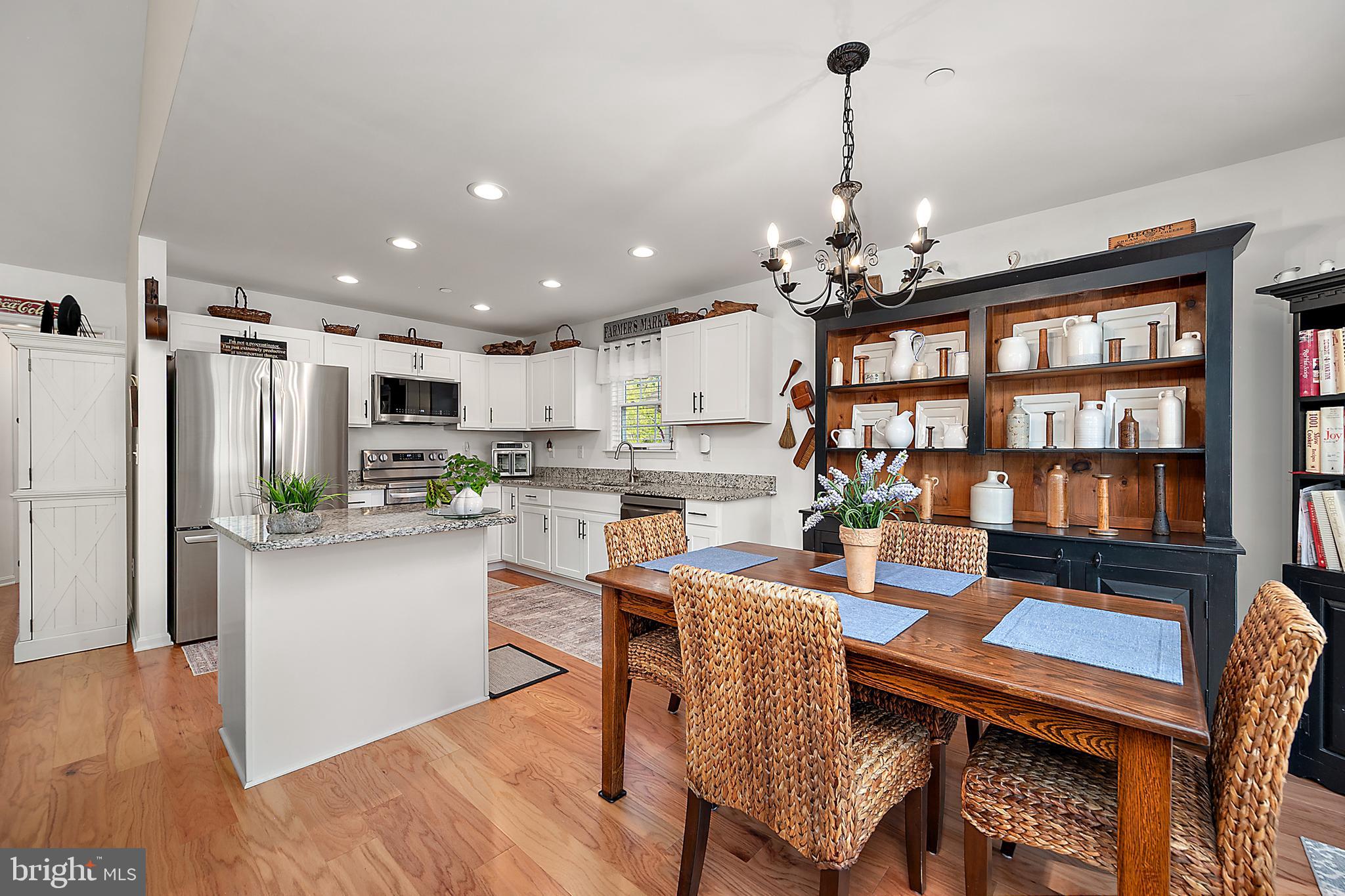6098 Tarry Town Road Salisbury, MD 21801 - Photo 23 of 60 a dining room with stainless steel appliances kitchen island granite countertop a dining table chairs and a refrigerator