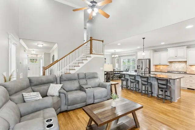 a living room with furniture kitchen view and a wooden floor