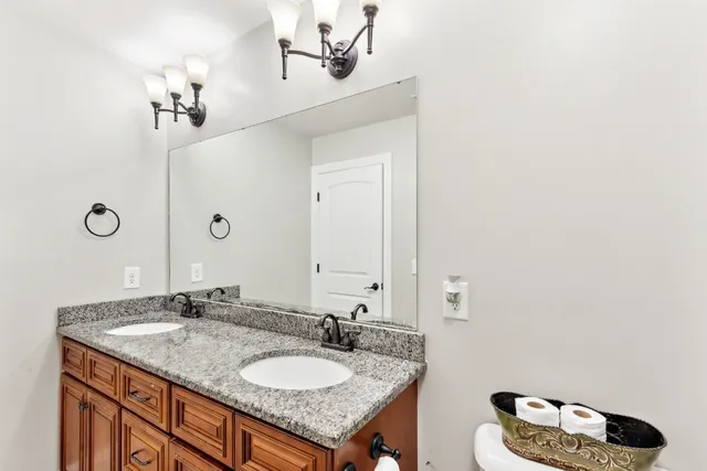 a bathroom with a granite countertop sink and a mirror
