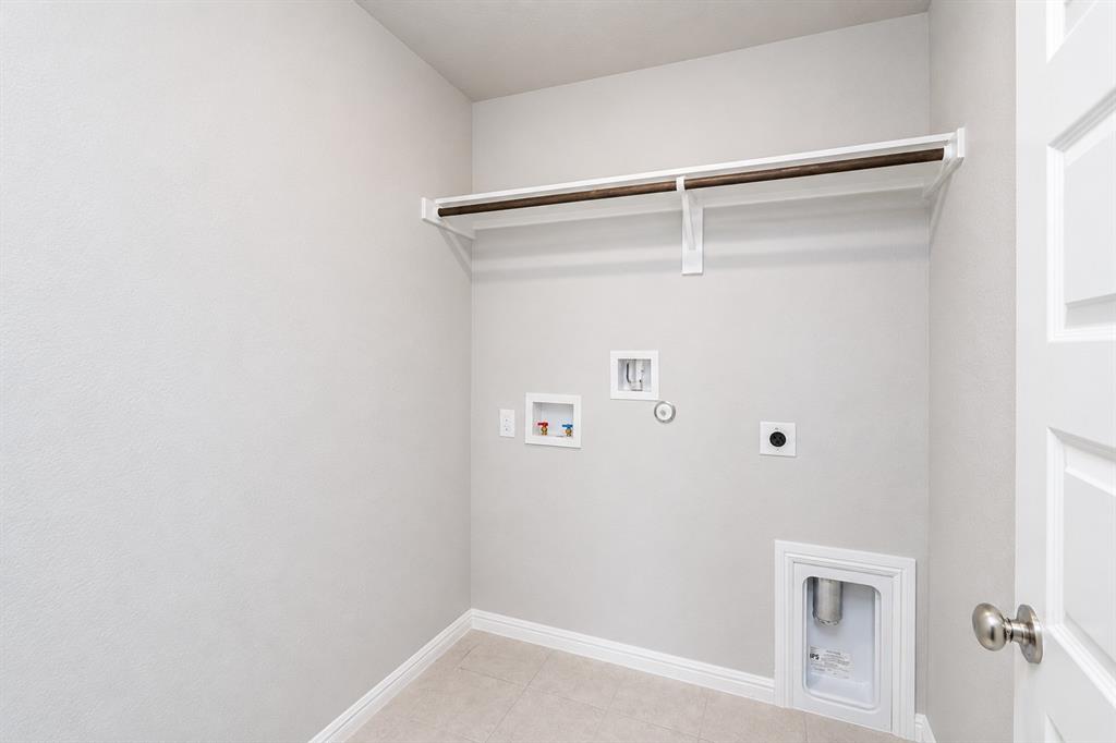 3344 Duncan Way Corinth, TX 76210 - Photo 23 of 38 Dedicated laundry space featuring a white garment rod and shelf, tile flooring, and a baseboard trim