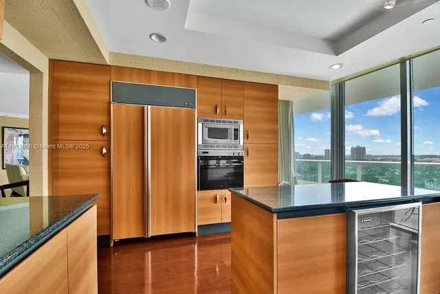 a kitchen with stainless steel appliances granite countertop a refrigerator and a stove