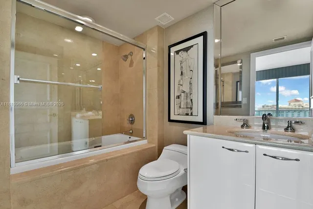 a bathroom with a double vanity sink toilet mirror and shower