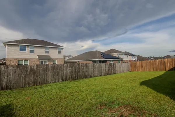 a front view of a house with a garden and trees