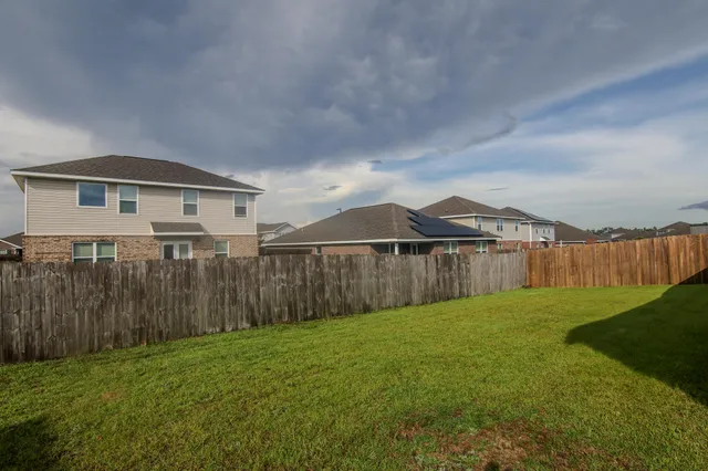 a front view of a house with a garden and trees
