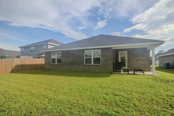 a brick building with a window and a yard