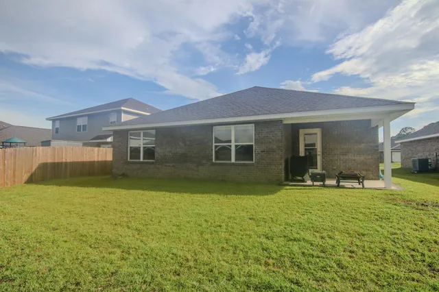 a brick building with a window and a yard